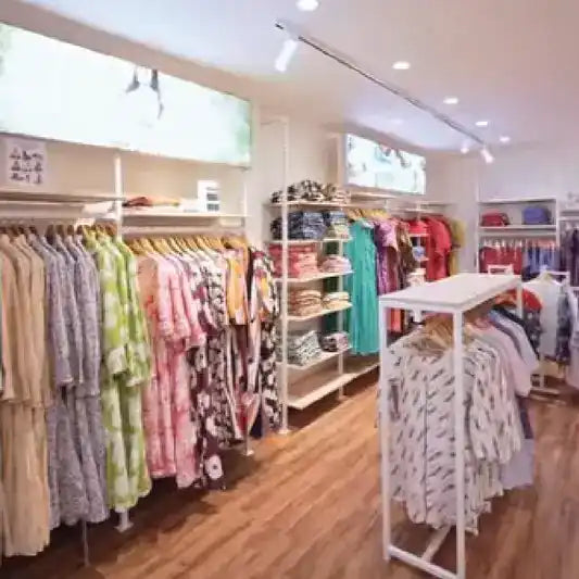 Clothing store interior with racks of clothes and shelves.