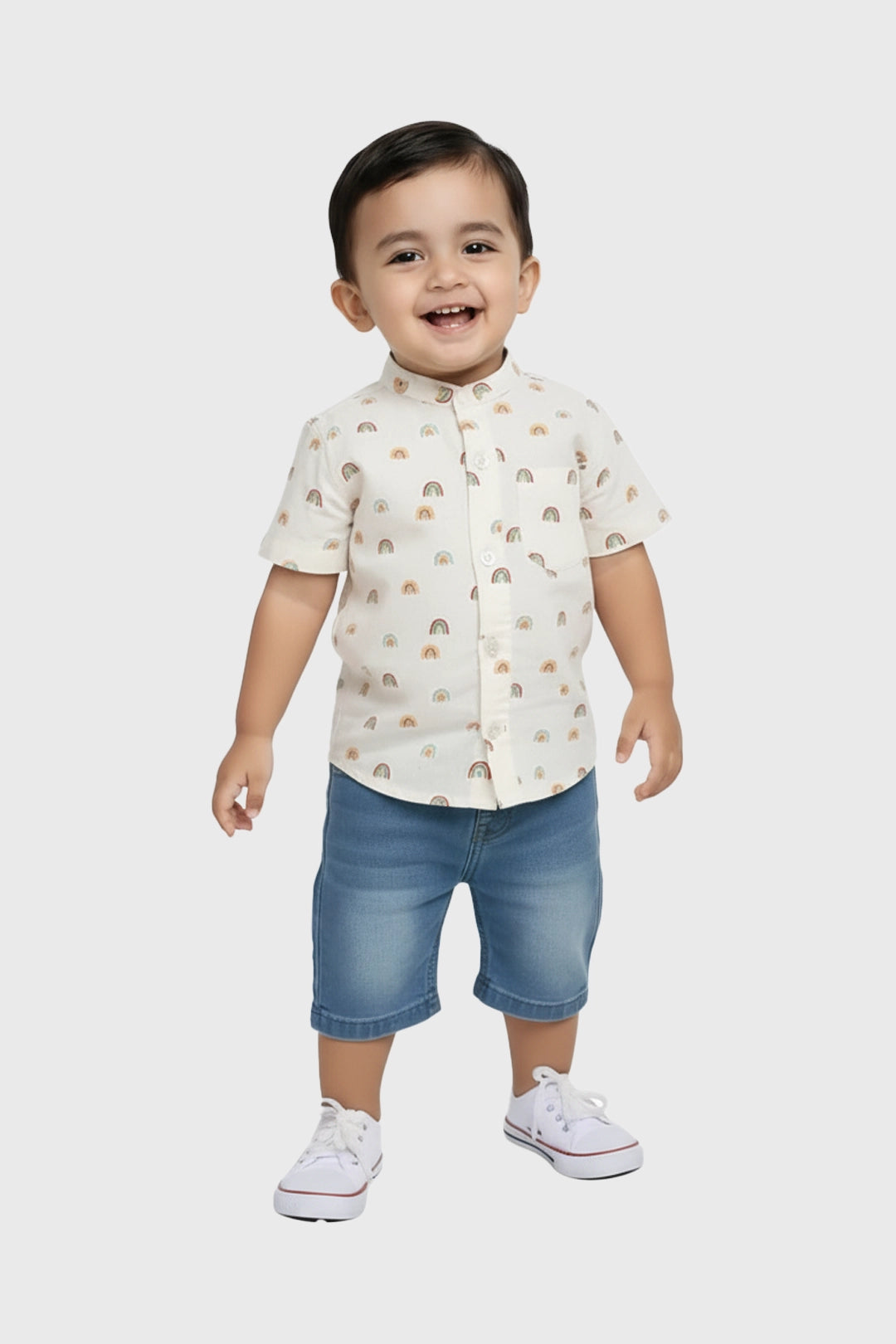 Child wearing a patterned shirt and denim shorts on a white background