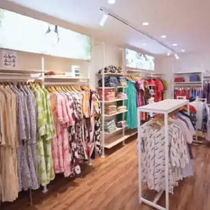 Clothing store interior with racks of clothes and shelves.
